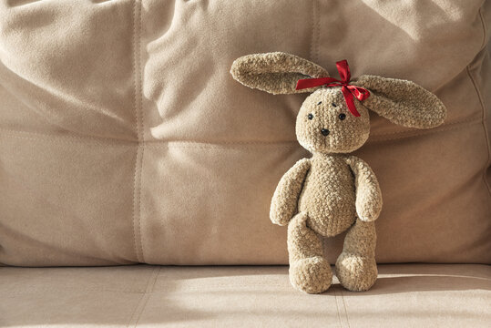 Brown crocheted toy bunny rabbit on sofa