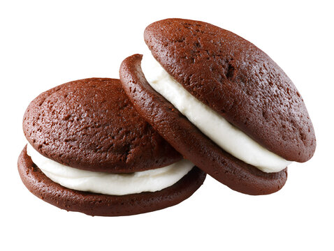 Two classic chocolate whoopie pies with creamy vanilla filling, soft cake-like sandwich cookies, isolated on a white background.