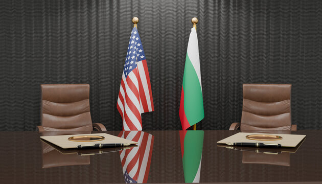 Diplomatic Summit: Two national flags, the United States and Bulgaria, stand proudly behind a polished table in a formal meeting room, symbolizing international relations and discussion.