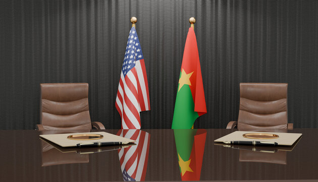 Bilateral Meeting: Two national flags stand prominently on a polished table in a formal meeting room, signifying international diplomacy and negotiation between two nations.