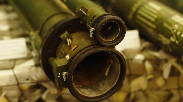The muzzle and optical sight mount end of a green anti-tank guided missile (ATGM) launch tube close up.