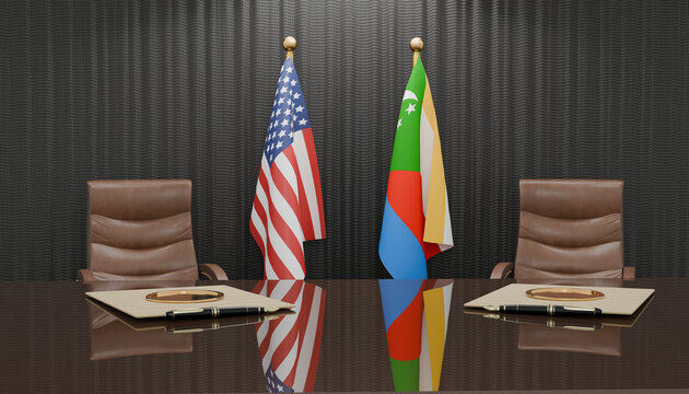 Diplomatic Meeting Room: Two flags, the United States and Comoros, stand tall behind empty leather chairs in a formal meeting room, symbolizing international relations and discussion.