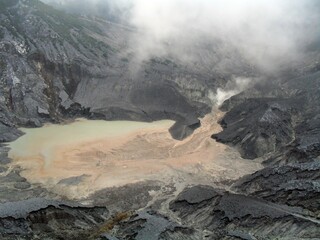 Volcanic mountain crater with dramatic sulfur smoke and rock formations, wide-angle landscape shot for travel and nature documentation © Vincent