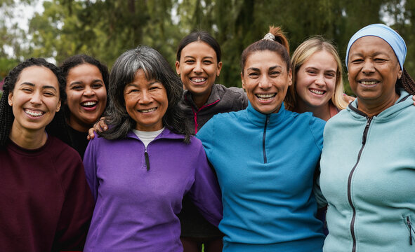 Happy women with different ethnic and body having fun smiling on camera outdoor - Multiracial female group hugging each other at city park 