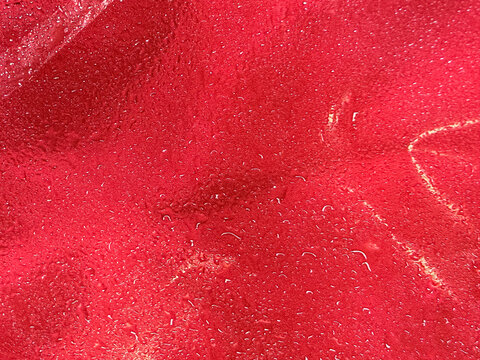 Red fabric texture with water droplets