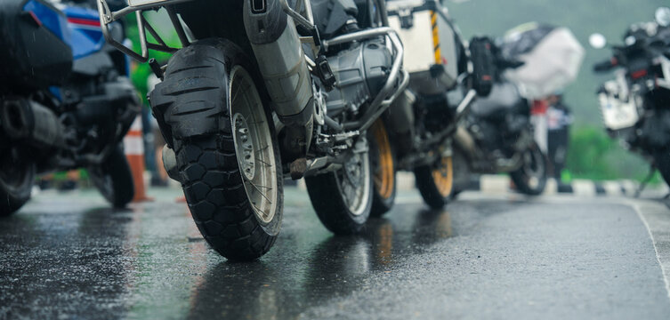 Motorcycles parked on wet pavement after rain, reflecting sense of adventure and freedom