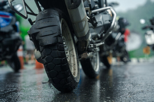 Close up of motorcycle tire on wet road, showcasing rugged tread design and adventure ready features