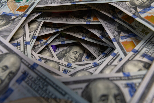 Benjamin Franklin portrait inside a swirling tunnel of US one hundred dollar bills
