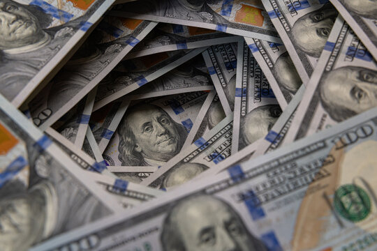 Benjamin Franklin portrait inside a swirling tunnel of US one hundred dollar bills
