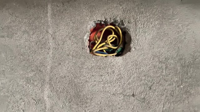 Electrical Junction Box with Yellow Wires in Concrete Wall Under Construction