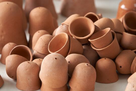 Pottery. A variety of fired clay blanks for future handbells sit on a pottery workshop table.