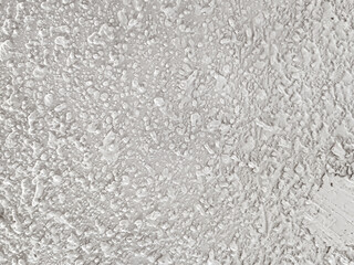 Background of uneven white acoustic wall texture with abstract grain patterns accentuates the modern industrial aesthetic. Close-up of handmade popcorn ceiling has dramatic shadows for decoration. © Windi Holly