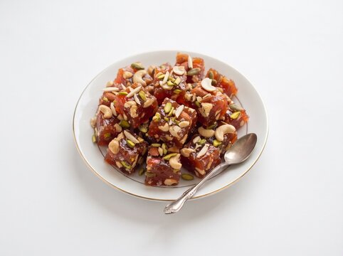 Traditional Karachi Halwa garnished with nuts served on a white plate.. Top View