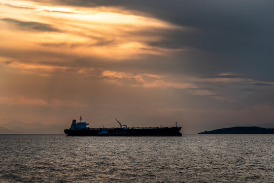 Crude oil tanker in the sea at fiery sunset. Oil and gas industry. Tankers crude oil carrier ship designed for transporting grude oil