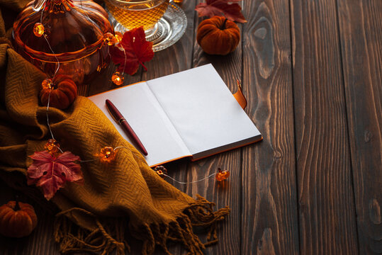 Autumn cozy tea scene with notebook and pen