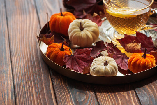 Autumn comfort with tea, pumpkins, and fall leaves
