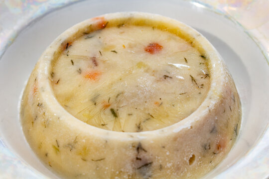 Traditional aspic meat jelly with vegetables served in a white ceramic bowl for appetizer