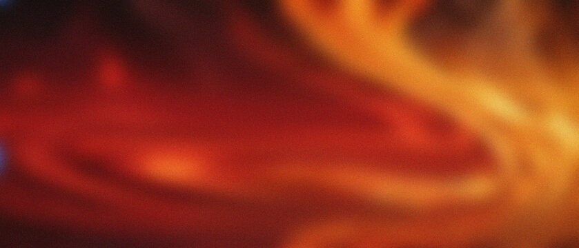 Molten subterranean heat undulates with intense granular textures, showcasing fiery red, orange, and golden currents in a diffused, abstract flow.