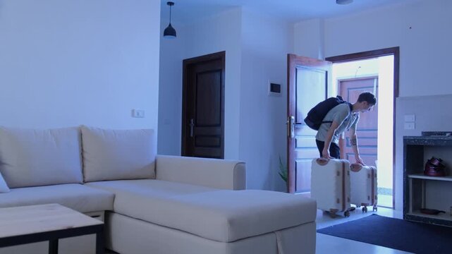 Young man leaving furnished apartment with luggage after temporary stay, housing instability, flexible living, nomadic lifestyle and uncertain future transition concept