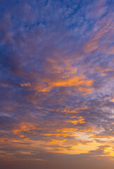 Obraz premium Dramatic Golden Sunset Sky with Vibrant Clouds,A breathtaking view of a dramatic sunset sky filled with vibrant golden and purple clouds, creating a peaceful and inspiring atmosphere for nature.