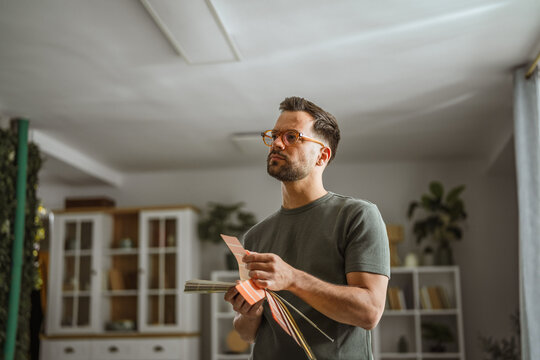 Man choosing paint color with swatches for renovation
