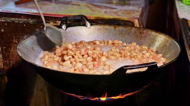 Fresh pork skin pieces frying in bubbling oil, capturing the essence of homemade crispy pork rind snack.