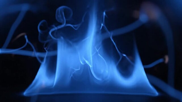 Abstract blue fire flames and ethereal smoke wisps dancing against a dark black background