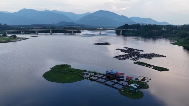 A peaceful river scene featuring floating gardens and a small house surrounded by calm water at Tasik Raban