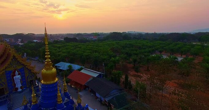 Aerial View The magnificent blue stupa and richly decorated temple structures showcase exquisite Thai craftsmanship and Buddhist artistry at Wat Rong Suea Ten. Ornate Blue Church and Stupa at Sunrise