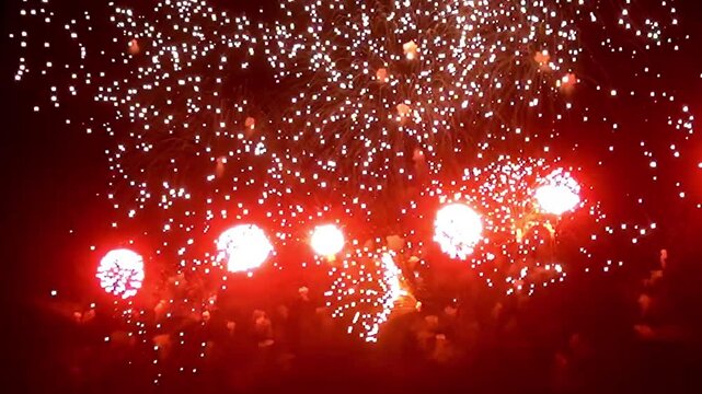 Brilliant bursts of color light up the night sky as fireworks explode in dazzling patterns, creating a breathtaking spectacle during the summer celebration.