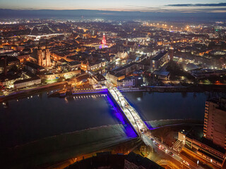 Panoramy nocnego Opola z lotu ptaka z podświetlonym mostem nad Odrą i iluminacją Rynku. Widok na stolicę województwa opolskiego w świątecznym oświetleniu. © Henryk Niestrój