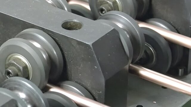 Explore the intricate process of an industrial machine molding copper tubes. Watch as the parts come to life in slow motion, showcasing precision and craftsmanship in manufacturing.