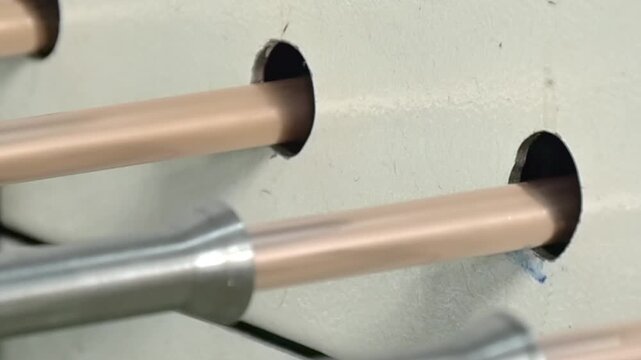 Focused on the intricate process of manufacturing copper tubes, this close-up view captures the slow motion movement of the machine as tubes are expertly produced for air conditioners.