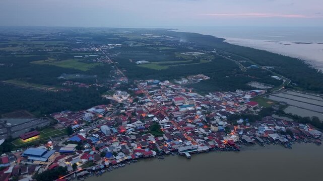 Dusk settles over a coastal village nestled beside calm waters at Sungai Udang, Penang