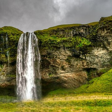 powerful waterfall cascading over mossy cliffs