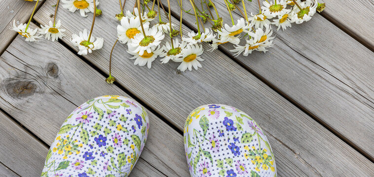 Margeritenstrauss auf eienm Holzboden und Gartenschuhen