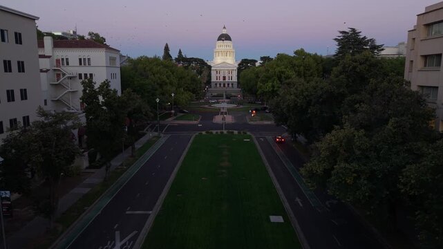 Aerial views show the west side of the California State Capitol in Sacramento at night. The new annex is under construction to the east.