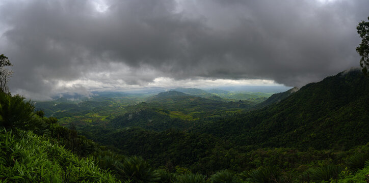 Dramatic panoramic landscape of lush green mountains under dark stormy clouds in Umphang Tak Thailand