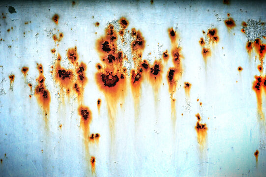 Close-up of rusty painted metal surface with corrosion and oxidation. Detailed industrial texture for grunge backgrounds, construction concepts and distressed material designs.