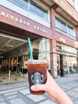 Prague, Czech republic - June 8, 2026: Hand holding starbucks iced coffee in prague
