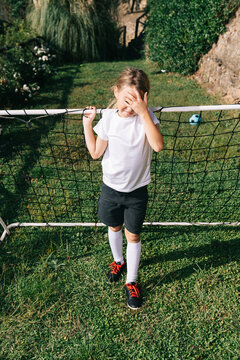 Girl goalkeeper standing in backyard soccer goal