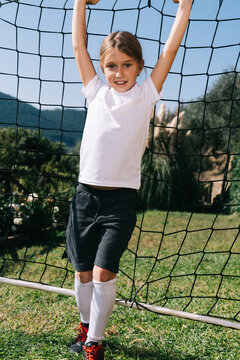 Girl spinning around with a soccer goal