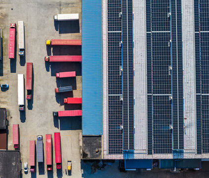 logistics yard with trucks and solar rooftop warehouse