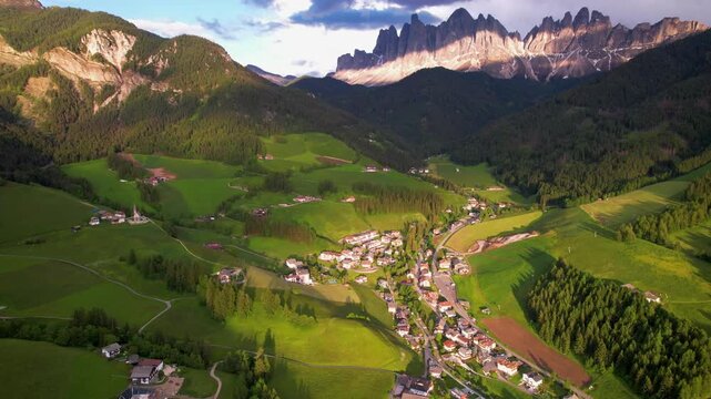 Val di Funes Santa Maddalena Italy 4K Drone. Aerial flight over village toward Odle mountain peaks in sunset golden hour. Majestic Dolomites landscape b roll cinematic travel stock video asset