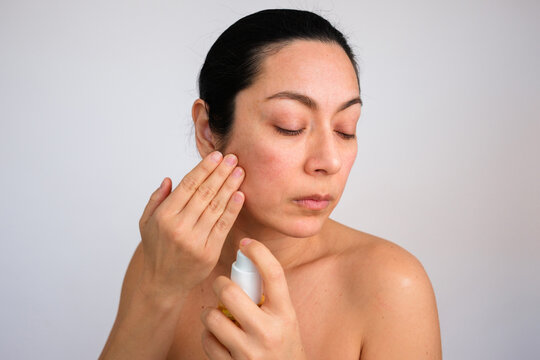 Skin Care Routine Involves Applying Product on Face by a Woman