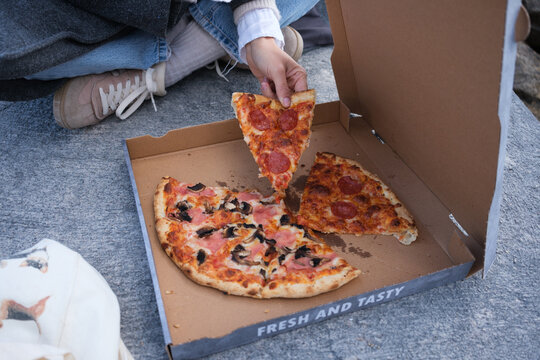 Pizza is Shared Among Friends During a Picnic in the Street