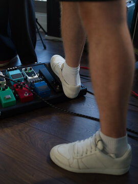 Foot Presses a Guitar Pedal During a Music Session in a Studio
