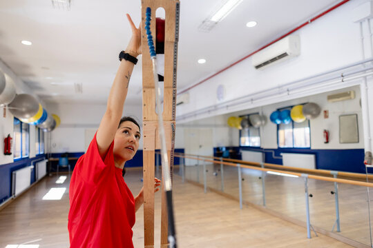 Woman measuring vertical jump performance in gym