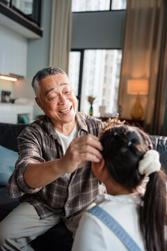 Grandfather places a crown on his granddaughter's head.