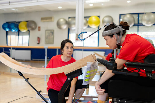 Woman with disability practicing boccia with a trainer